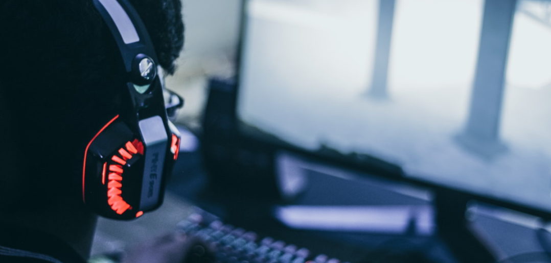 Mann spielt am PC mit Headset