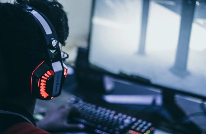 Mann spielt am PC mit Headset